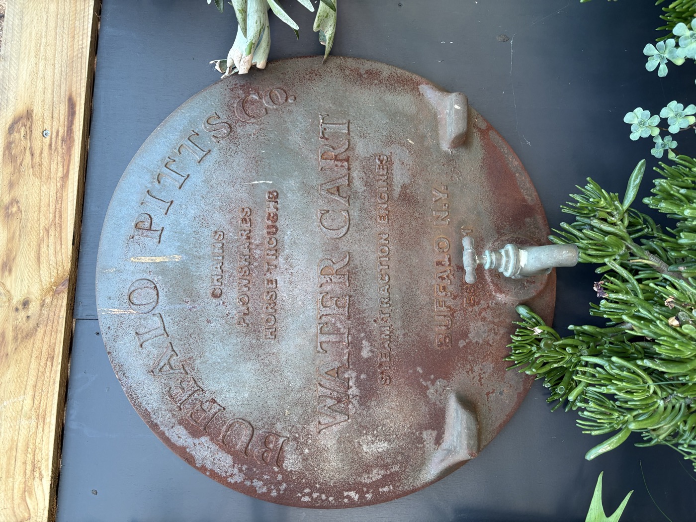 A beautiful rustic cast iron Buffalo Pitts Water Cart disc — part of the nursery's unique character